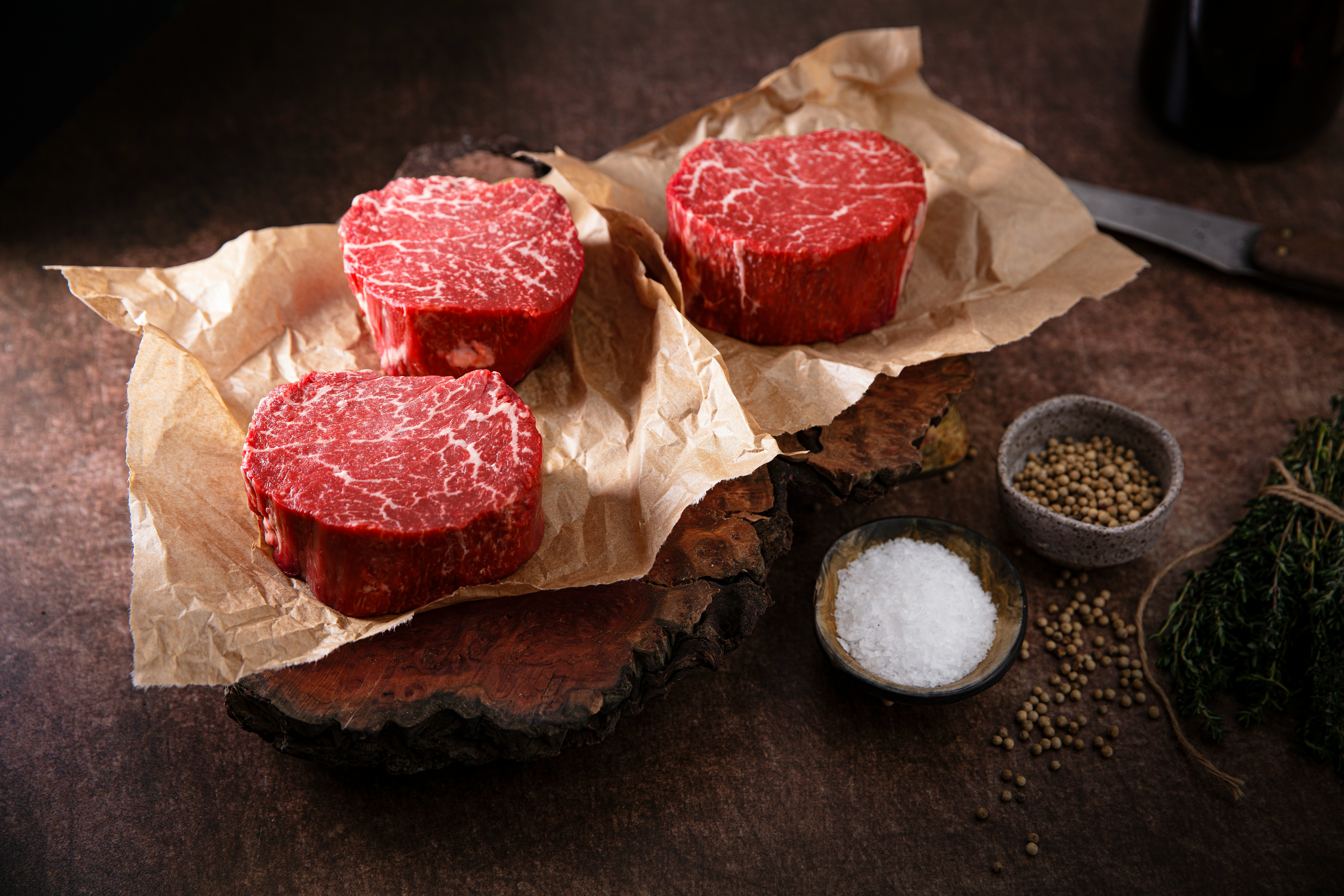 premium filet steaks on dark stone surface, professional food photography, high-end, detailed meat texture